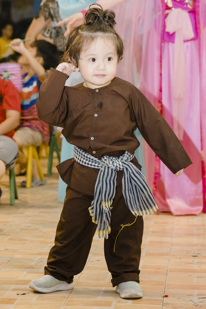 Cu Tết diện trang phục chú Cuội, thắt khăn rằn ở eo, thích chạy theo mẹ và các anh chị.
