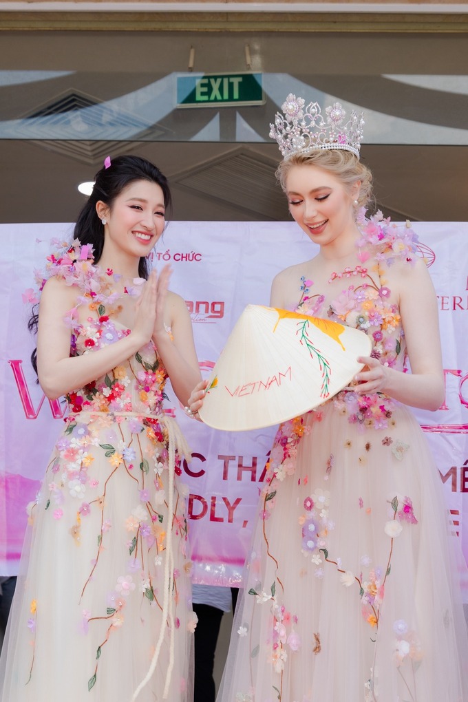 Jasmin Selberg mặc đầm đôi cùng Phương Nhi tại sự kiện chào đón cô đến Việt Nam sáng 23/5. Trang phục mang phong cách nữ tính, sử dụng chất liệu voan, đính hoa do nhà thiết kế Tùng Vũ.