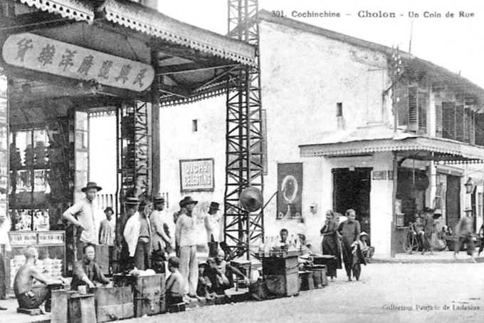 Những người dân bán đồ ăn trên vỉa hè, trước một tiệm tạp hóa, nay là góc đường Trần Ngũ Lão - Phạm Đôn (quận 5). Ảnh được giới thiệu trong sách Kiến trúc đô thị và cảnh quan Sài Gòn - Chợ Lớn xưa và nay, do Nhà xuất bản Tổng hợp TP HCM phát hành giữa tháng 7. Ấn phẩm do các tác giả Nguyễn Đức Hiệp, Tim Doling, Võ Chi Mai thực hiện, nguồn ảnh được chọn lọc trong nhiều năm từ các tạp chí, tư liệu đầu thế kỷ 20.Theo sách, Chợ Lớn (ngày nay là quận 5, quận 6, TP HCM) được hình thành từ thế kỷ 17 đến 19, khi cộng đồng người Hoa đến định cư, xây dựng một đô thị sầm uất. Năm 1956, Sài Gòn - Chợ Lớn được gọi tên thống nhất là Sài Gòn.