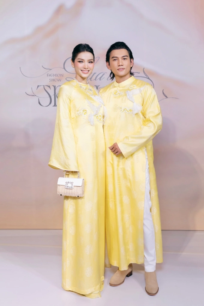 Trang phục đính họa tiết chim ở ngực tạo điểm nhấn. Phương Trinh Jolie phối áo dài với vòng cổ ngọc trai, xách túi phong cách cổ điển. Tại show, cặp sao còn tham gia trình diễn trên sàn runway.