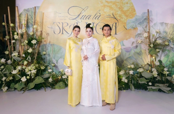 Tối 30/9, Linh San (giữa) thực hiện show Lụa là trà hoa, giới thiệu bộ sưu tập áo dài phong cách truyền thống xen lẫn phá cách. Trên thảm đỏ, nhà mốt đón hàng trăm sao tham dự, chúc mừng. Diễn viên Phương Trinh Jolie và chồng Lý Bình diện áo dài đôi.