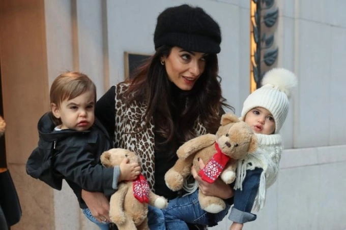 Luật sư Amal Clooney bế hai bé Alexander (trái) và Ella năm 2018. Đây là lần hiếm hoi gia đình Clooney để lộ mặt hai bé. Ảnh: SplashNews