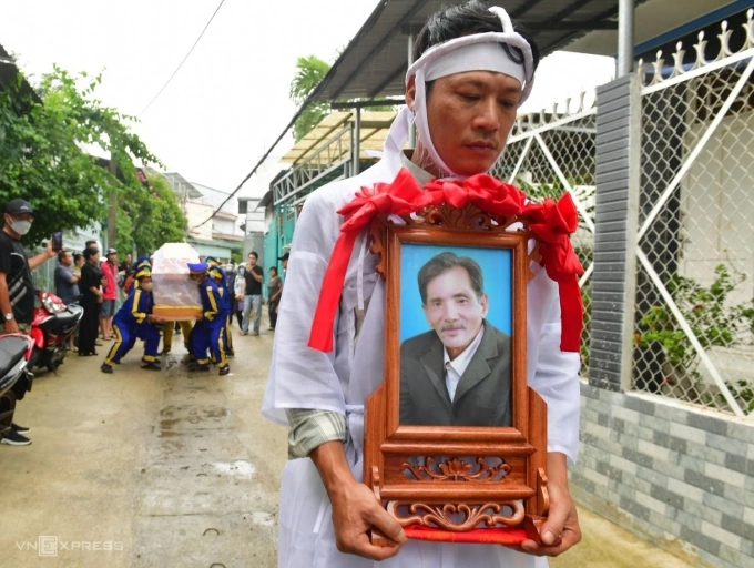 Con trai Thương Tín - anh Thanh Tùng - bên di ảnh cha. Ảnh: Thanh Tùng