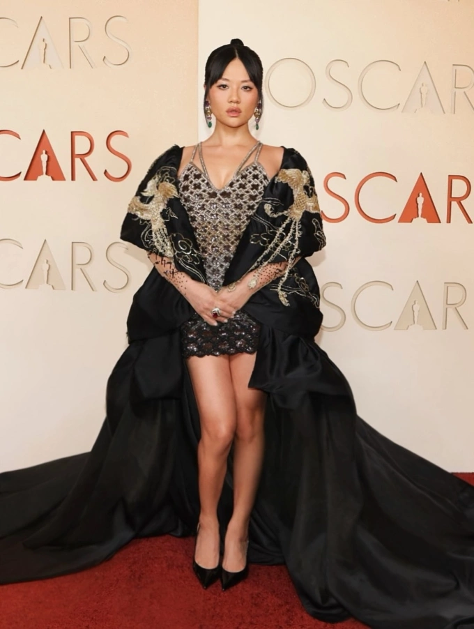 Rei Ami diện váy Rahul Mishra phối áo choàng dài quét sàn trên thảm đỏ Oscar 2026. Ảnh: Instagram Rei Ami