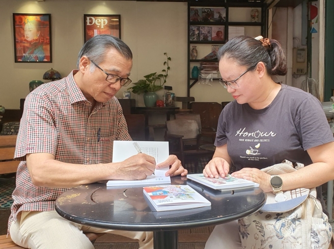 Tác giả Phạm Công Luận (trái) ký tặng sách độc giả vào sự kiện giao lưu, ở Đường Sách TP HCM hôm 11/4. Ảnh: Nhân vật cung cấp